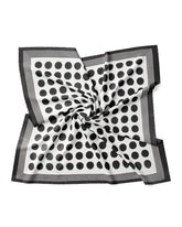 A silk scarf featuring a black and white polka dot pattern, elegantly displayed against a white background.