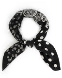 A chic black and white polka dot bandana made of silk, beautifully knotted for a sophisticated touch.