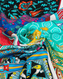Close-up view of a colorful silk scarf adorned with a lively pattern of bags, highlighting its exquisite design.