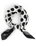 A luxurious silk scarf featuring a black and white polka dot pattern, elegantly knotted for a sophisticated look.