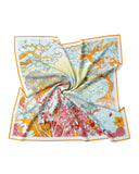  A silk scarf featuring a beautifully illustrated tree adorned with vibrant flowers.