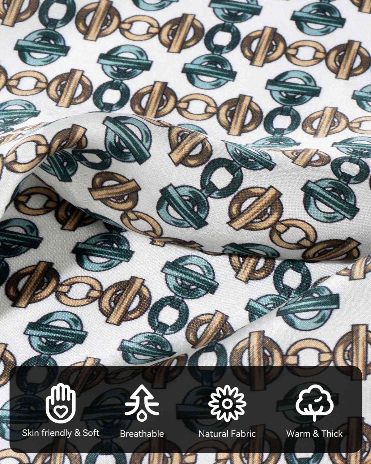 A close-up of a silk scarf with green and brown geometric pattern and various symbols highlighting the characteristics and details of its material.