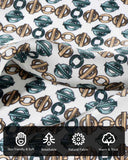 A close-up of a silk scarf with green and brown geometric pattern and various symbols highlighting the characteristics and details of its material.