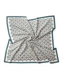 A silk scarf featuring a green and white geometric pattern, elegantly designed in a square shape.