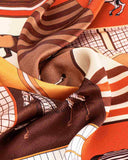 Close-up of a silk scarf featuring an intricate horse design, showcasing vibrant colors and fine details.
