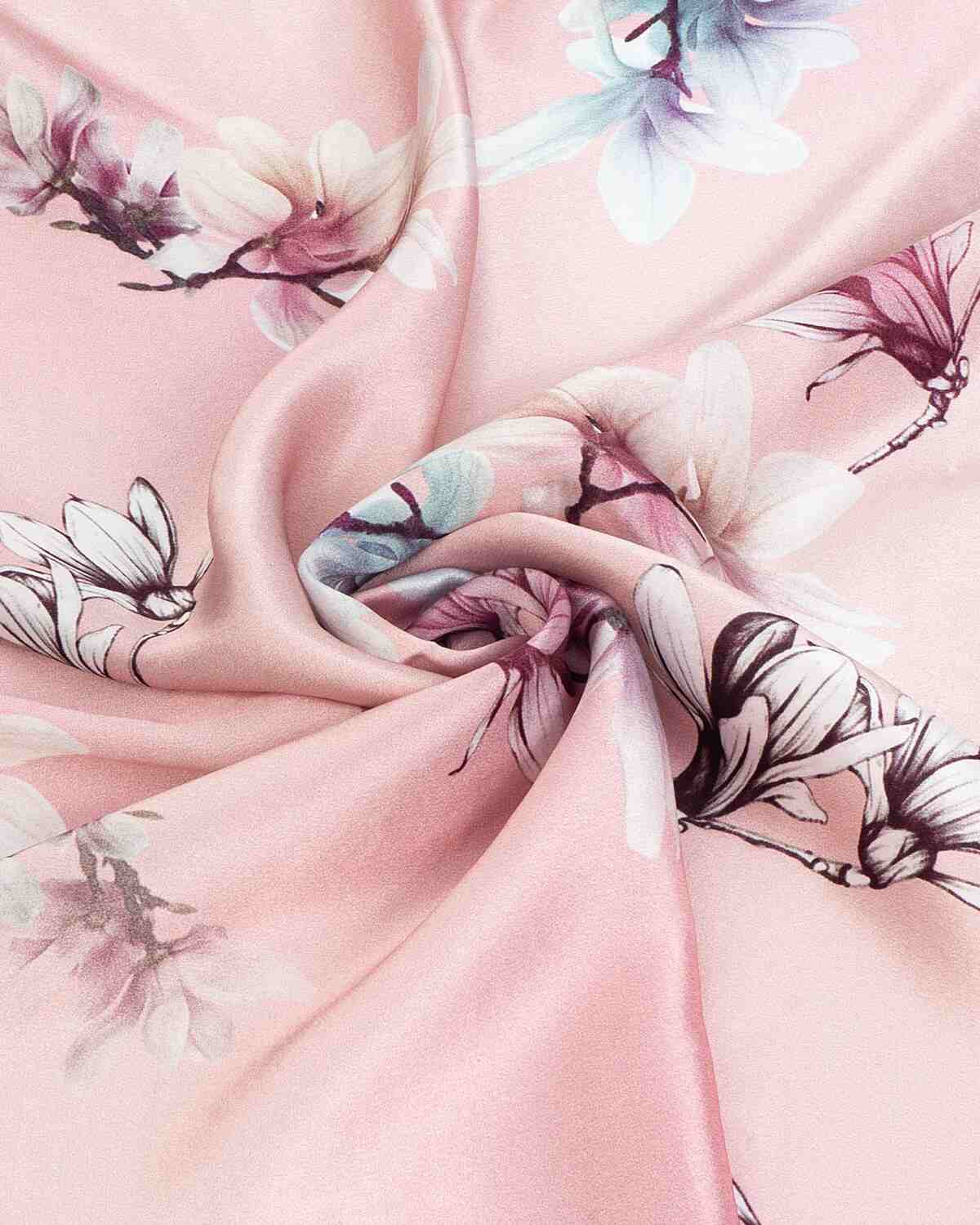 Close-up of a pink silk scarf adorned with delicate white flowers, showcasing its elegant texture and design.