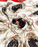 Detailed view of a silk scarf showcasing a white and black color scheme adorned with a red and black motif.