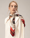 A woman models a white top paired with a luxurious silk red scarf, exuding elegance and fashion.